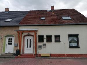 a white house with a red roof at Ferienwohnung altes Steinlager in Oderberg