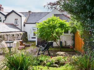 a garden with a chair in front of a house at Fairground Cottage in Rothbury