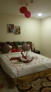 a bedroom with a large bed with red decorations on it at Burj Alawal in Al Jubail