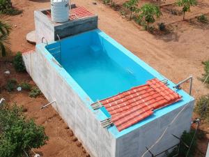 an overhead view of a large swimming pool at MangoHut Farmhouse Pool Villa in Hyderabad