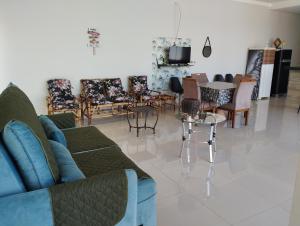 ein Wohnzimmer mit einem Sofa, Tischen und Stühlen in der Unterkunft Casa de temporada em olimpia sp thermas laranjais in Olímpia