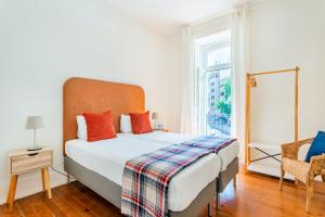 um quarto com uma cama grande e uma janela em Conde 3BDR Luxury em Lisboa