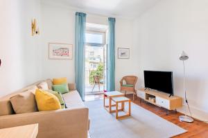 uma sala de estar com um sofá e uma televisão em Conde 3BDR Luxury em Lisboa