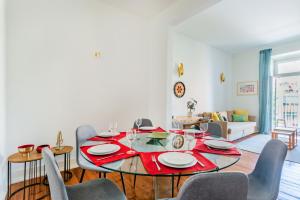 uma sala de jantar com uma mesa vermelha e cadeiras em Conde 3BDR Luxury em Lisboa
