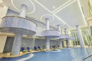 a large lobby with blue chairs and large chandeliers at Pickalbatros Blu Spa Resort - Adults Friendly 16 Years Plus- Ultra All-Inclusive in Hurghada