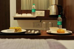 einen Tisch mit zwei Teller mit Lebensmitteln und Wasserflaschen in der Unterkunft Gateway Inn in Bangalore