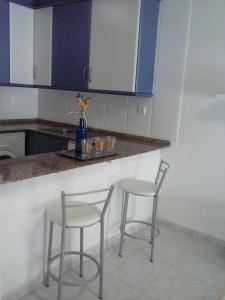 a kitchen with two chairs and a counter with blue cabinets at Apartment Cambrils Beach and Center in Cambrils