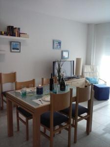 a dining room table and chairs with a table and a television at Apartment Cambrils Beach and Center in Cambrils