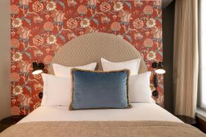 um quarto com uma cama com uma almofada azul em Hotel Fior d'Aliza em Paris