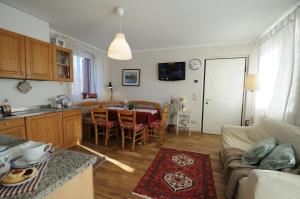 Una cocina y una sala de estar con una mesa. en Delizioso appartamento, en Feltre