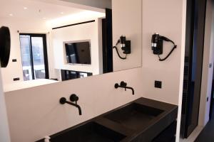 a bathroom with a sink and a mirror at White and Black Aegina in Áyioi Asómatoi