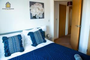 a bedroom with a bed with blue and white pillows at Cosy 2 Bed Flat Sleeps 4 with Free Parking by Amazing Spaces Relocations Ltd in Warrington
