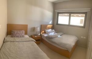 1 Schlafzimmer mit 2 Betten und einem Fenster in der Unterkunft Tawila, 4 Bedroom Villa, Brand new, directly on a lagoon in Hurghada