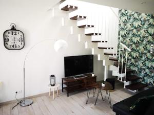 a living room with a staircase and a tv at Le Séduisant in Sainte-Anne-sur-Vilaine