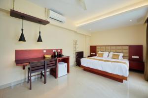 a bedroom with a desk and a bed and a desk at Thekkady Gavi Suites in Vandiperiyār