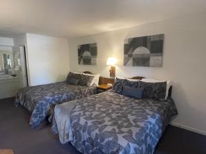 ein Hotelzimmer mit 2 Betten und einer Lampe in der Unterkunft Scottish Inns Motel - Osage Beach in Osage Beach