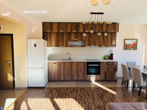 eine Küche mit Holzschränken und einem weißen Kühlschrank in der Unterkunft Ani's Guest House in Tschepelare