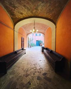 un corridoio vuoto con panchine in un edificio di B&B letterario Palazzo Pistocchi a Teramo