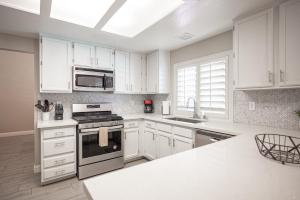 a kitchen with white cabinets and a stove top oven at Brilliant 4 Bedroom House With Pool! in Las Vegas