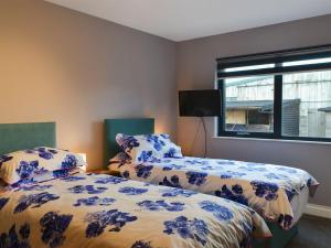 a bedroom with two beds with blue and white sheets at Brewers Cottage in Slaley