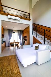 een slaapkamer met een groot wit bed en een tafel bij De Hsahe Villas in Tanah Lot