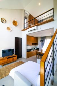 een woonkamer met een trap naar een loft bij De Hsahe Villas in Tanah Lot