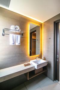 een badkamer met een wastafel en een spiegel bij De Hsahe Villas in Tanah Lot