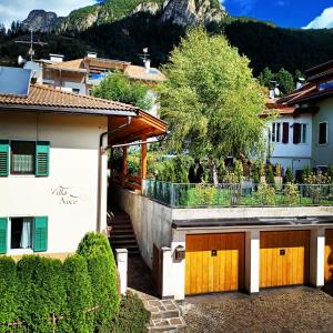 a house with wooden garage doors in a village at Villa Noce 2 in Tesero