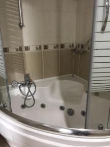 a bath tub with a shower in a bathroom at RZA HOTEL in Aşağı İmrahor