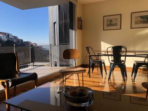 sala de estar con mesa y sillas y balcón en Lofts Vistalegre, en Valparaíso