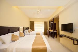 VandiperiyārにあるThekkady Gavi Suitesの大型ベッド1台、薄型テレビが備わるホテルルームです。