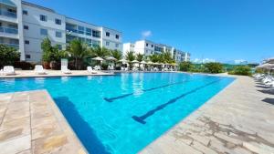 uma piscina num resort com água azul em Porto de Galinhas - Térreo com 03 quartos com suíte top- Condomínio Palm Village Acqua em Porto de Galinhas