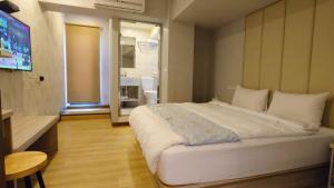 a bedroom with a large white bed and a television at Boutique HOTEL in Luodong