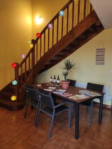 a dining room table with chairs and a staircase at Chez Sam in Villebois