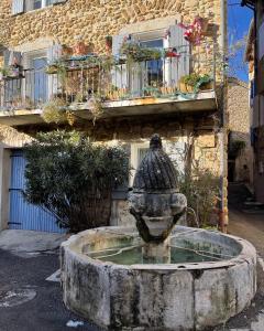 einen Steinbrunnen vor einem Gebäude in der Unterkunft Le Mas de Mirabel in Mirabel-aux-Baronnies