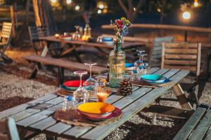 una mesa de picnic de madera con platos de comida y una botella en Antica Villa Colonica, en Sorso