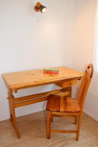 einen Holzschreibtisch mit einem Stuhl neben einem Tisch in der Unterkunft Unter den Linden - 3 in Dahme