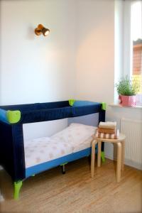 Schlafzimmer mit einem blauen Bett und einem Tisch in der Unterkunft Unter den Linden - 3 in Dahme