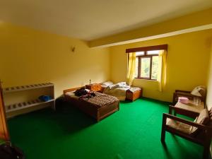 Habitación con 2 camas y suelo verde. en Hotel Pemathang en Pemayangtse