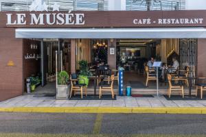 a cafe with tables and chairs in front of a building at Hotel Le Mus&eacute;e in Rabat