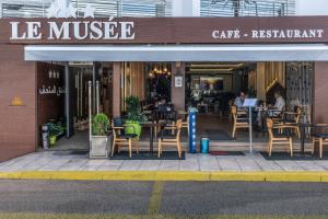 ein Café mit Tischen und Stühlen vor einem Gebäude in der Unterkunft Hotel Le Musée in Rabat