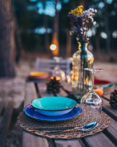 une table avec une plaque bleue et un verre de vin dans l'établissement Antica Villa Colonica, à Sorso