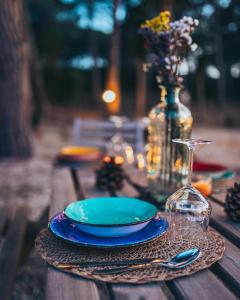 a table with a blue plate and a wine glass at Antica Villa Colonica in Sorso