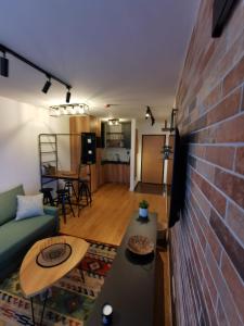 a living room with a couch and a brick wall at Apartman Dream Jahorina Snjezna Dolina in Jahorina