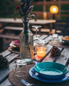 une table en bois avec un vase et des fleurs. dans l'établissement Antica Villa Colonica, à Sorso