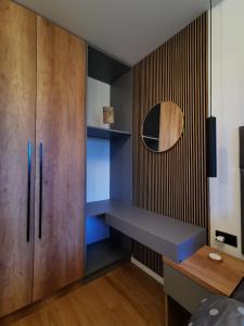 a bedroom with a wooden cabinet and blue shelves at Apartman Dream Jahorina Snjezna Dolina in Jahorina