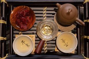 uma mesa com tigelas, um bule de chá e uma colher em Daruma Home em Da Lat