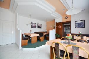 a living room with tables and chairs and a dining room at Penzion Jany in Luhačovice