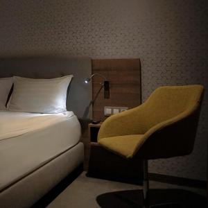 a bedroom with a bed and a chair and a lamp at Abton Hotel in Łódź