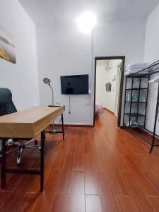 a room with a desk and a tv and a wooden floor at Casa Rebeca in Teror +3 photos